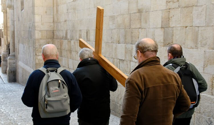 Man carrying cross on Via Dolorosa